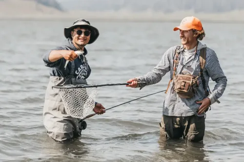 Two men fly fishing in a river.