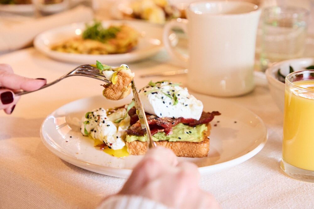 Poached eggs on avocado toast with bacon.
